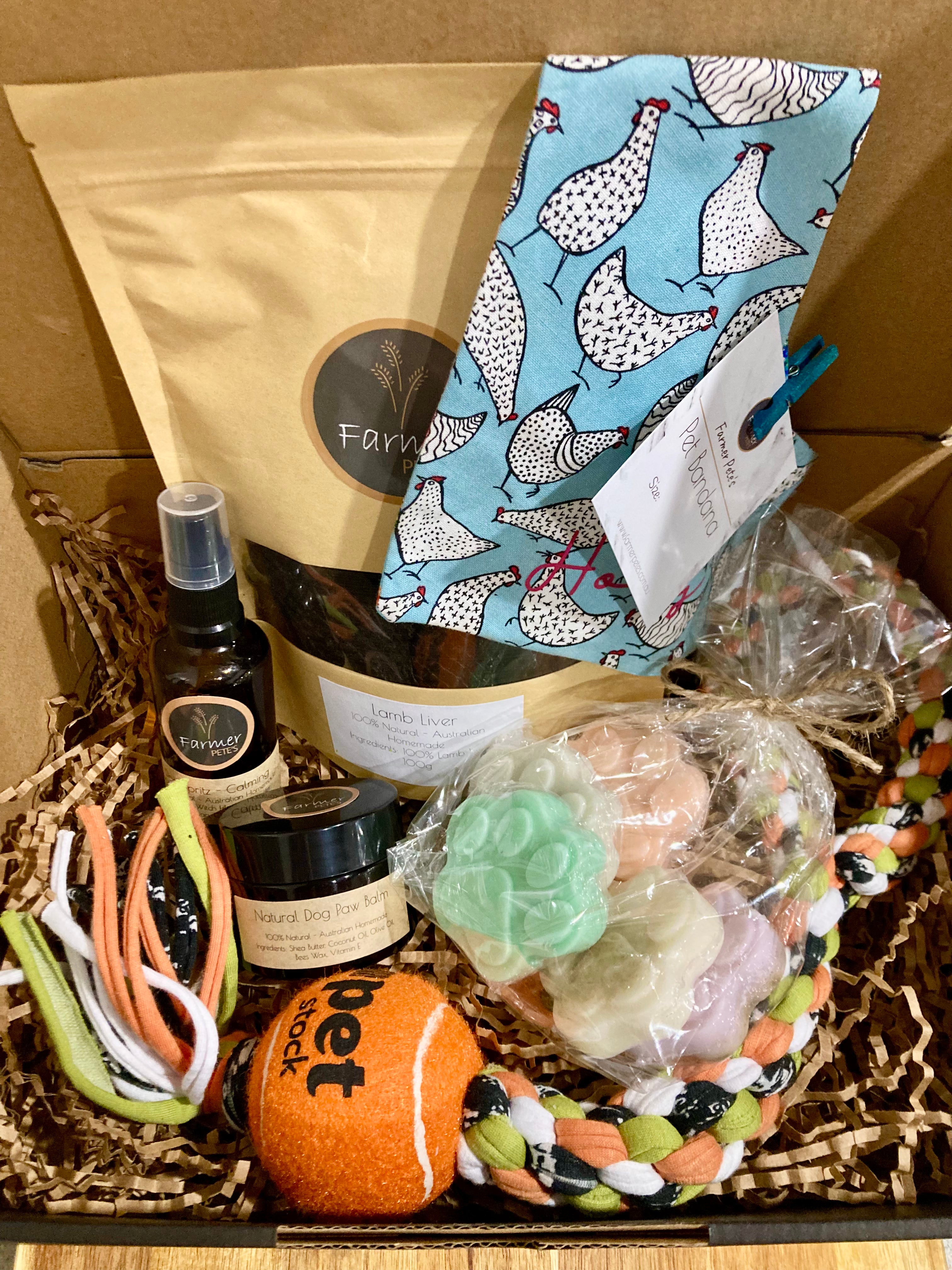 Pamper Your Pooch Box by Farmer Pete&#39;s, treats, personalised bandana, paw balm, spritz, paw soaps and a tug toy. 